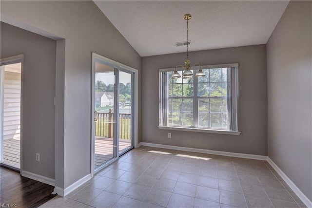 unfurnished dining area featuring an inviting chandelier, visible vents, baseboards, a textured ceiling, and vaulted ceiling