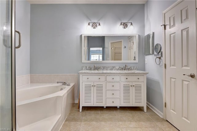 full bath featuring double vanity, a sink, a bath, and tile patterned floors