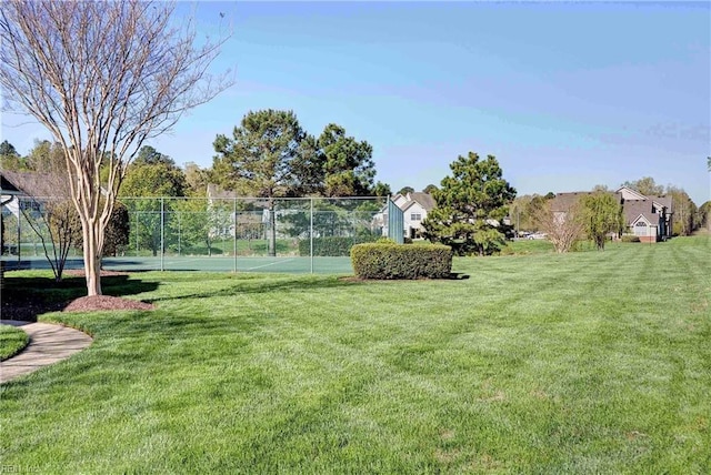 view of yard featuring a tennis court and fence