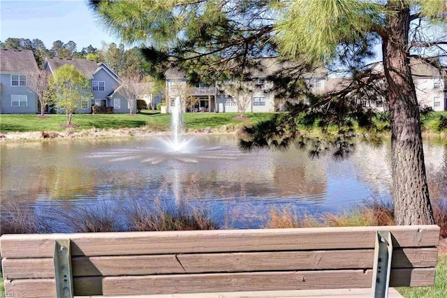 view of dock with a lawn, a water view, and a residential view