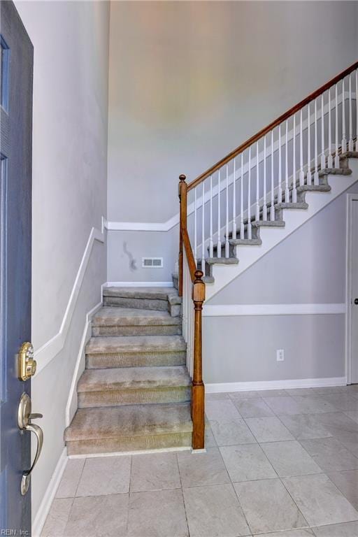 staircase featuring visible vents and tile patterned flooring
