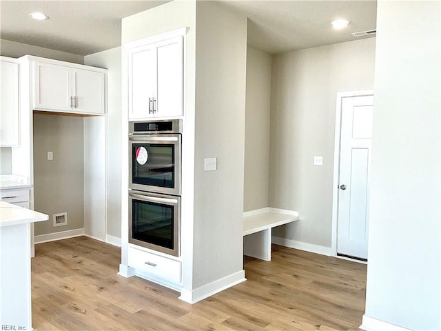 MM Savannah, Virginia Beach, VA 23456 - kitchen featuring white cabinets, light wood-type flooring, and stainless steel double oven