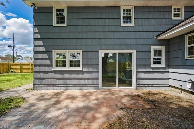 back of property featuring fence and a patio