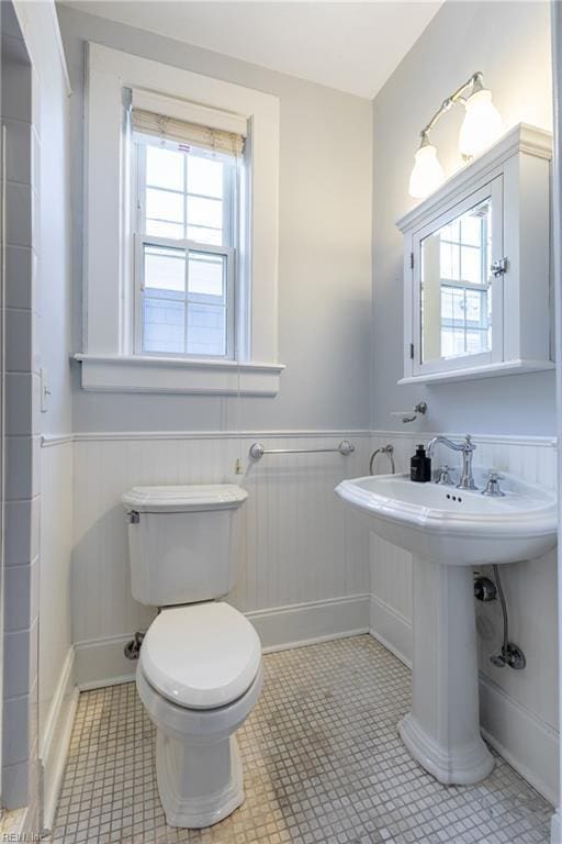 bathroom with a wainscoted wall and toilet