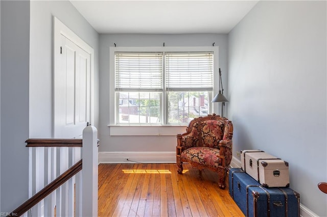 sitting room with baseboards and hardwood / wood-style flooring