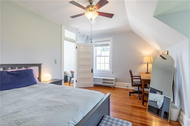 bedroom featuring ceiling fan, ornamental molding, vaulted ceiling, and wood finished floors