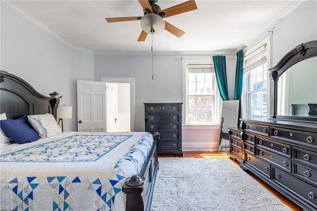 bedroom featuring a ceiling fan, baseboards, ornamental molding, and wood finished floors