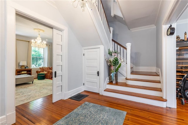 interior space with stairway, ornamental molding, hardwood / wood-style flooring, and a notable chandelier