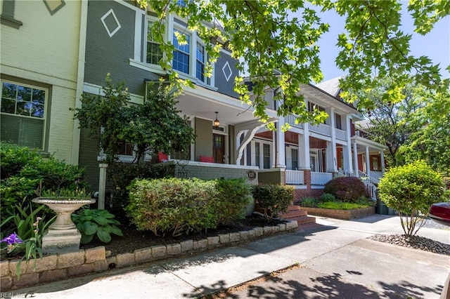 view of front of property featuring brick siding and covered porch