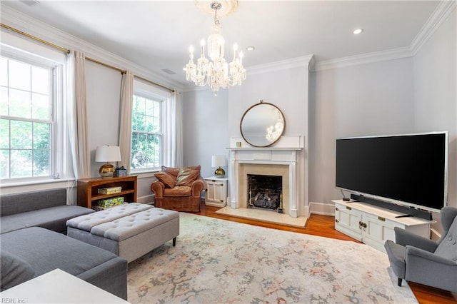 living room with crown molding, a high end fireplace, wood finished floors, and a chandelier