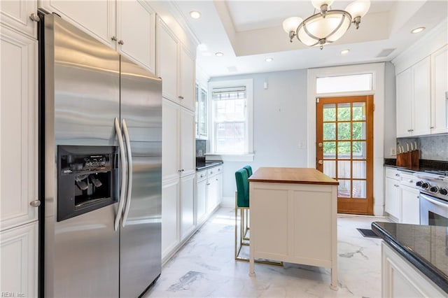 kitchen featuring marble finish floor, a notable chandelier, white cabinetry, and stainless steel appliances