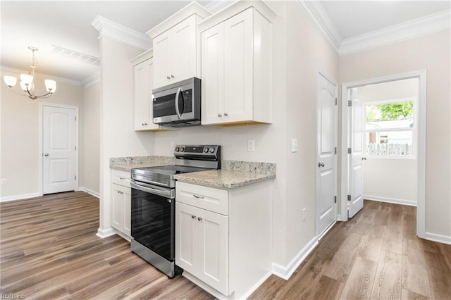 kitchen with crown molding, appliances with stainless steel finishes, a chandelier, and light wood-type flooring