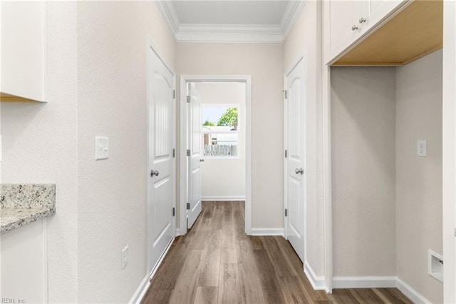 hall featuring baseboards, ornamental molding, and dark wood-style flooring