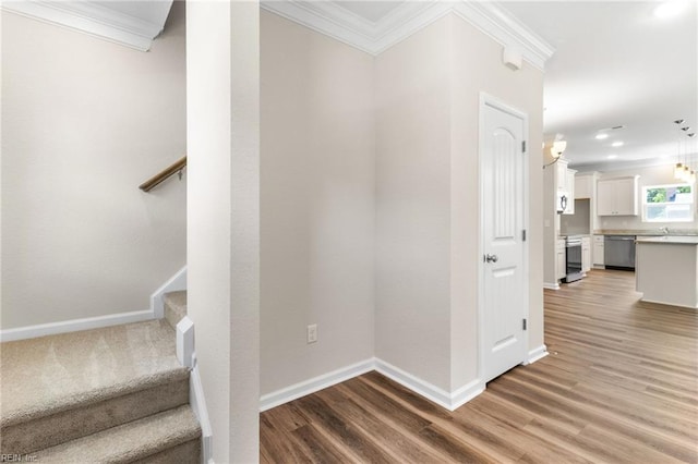 stairway featuring baseboards, ornamental molding, recessed lighting, and wood finished floors