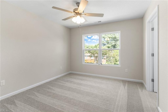 unfurnished room with baseboards, ceiling fan, light carpet, and visible vents