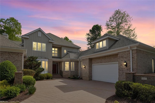 view of front facade with board and batten siding, decorative driveway, and brick siding