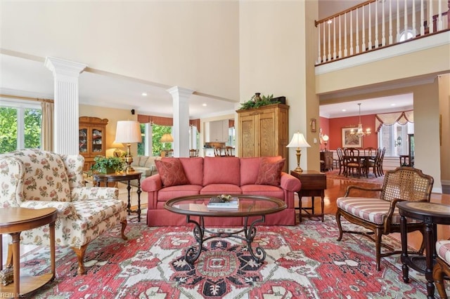 living area featuring plenty of natural light, recessed lighting, decorative columns, and a towering ceiling