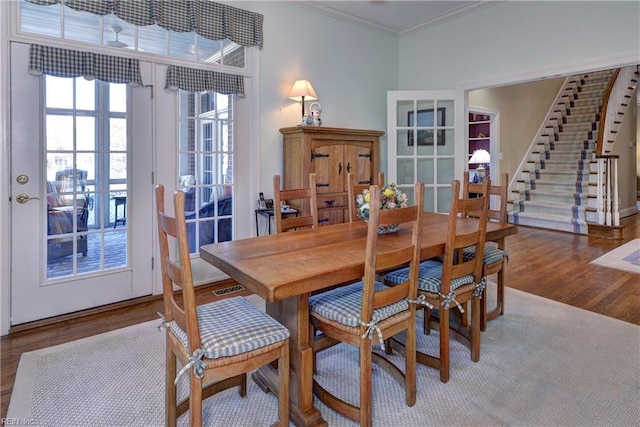 dining room featuring crown molding, french doors, stairs, and wood finished floors