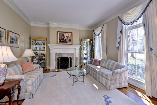 living room with visible vents, ornamental molding, wood finished floors, and a premium fireplace