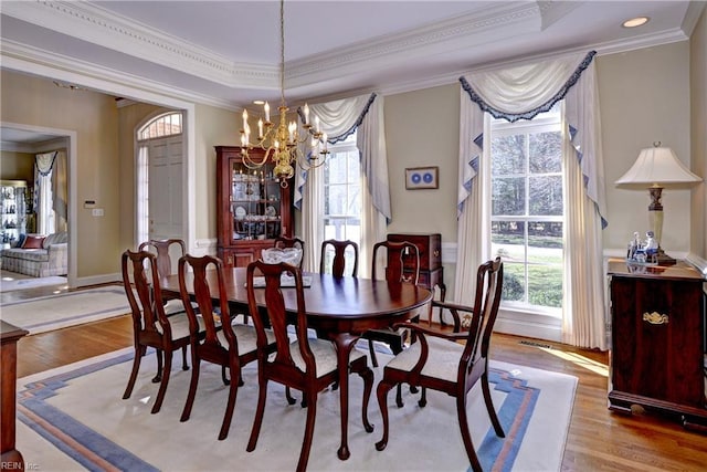 dining space with crown molding, a healthy amount of sunlight, and light wood-style floors