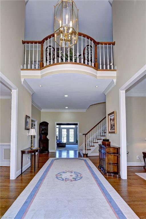 entryway with stairway, a high ceiling, and wood finished floors