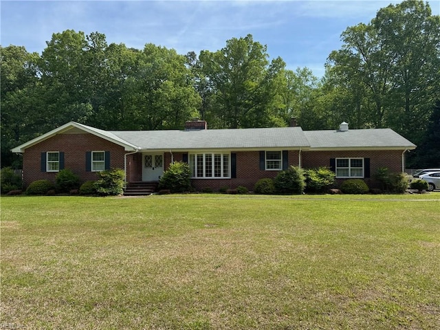 ranch-style house featuring brick siding, a chimney, and a front yard