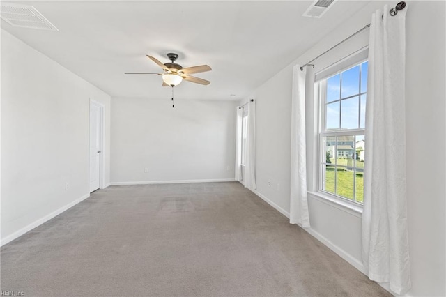 carpeted empty room featuring baseboards, ceiling fan, and visible vents