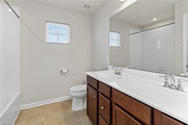 bathroom featuring toilet, a sink, and a wealth of natural light