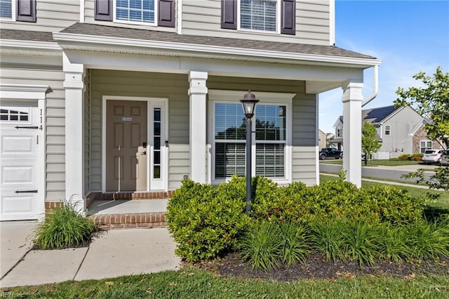 doorway to property featuring a garage and covered porch