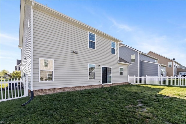 rear view of house with fence and a yard