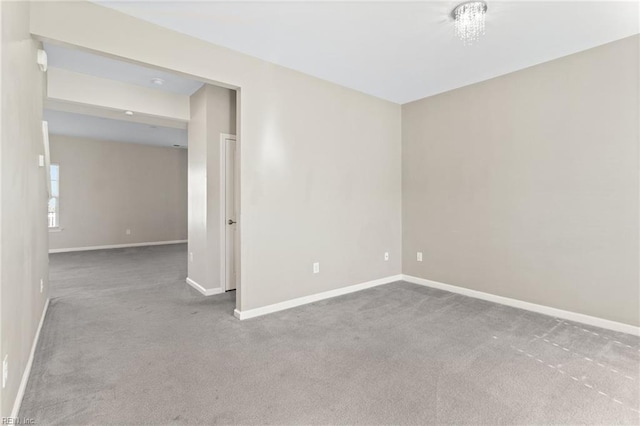 spare room with baseboards and carpet flooring
