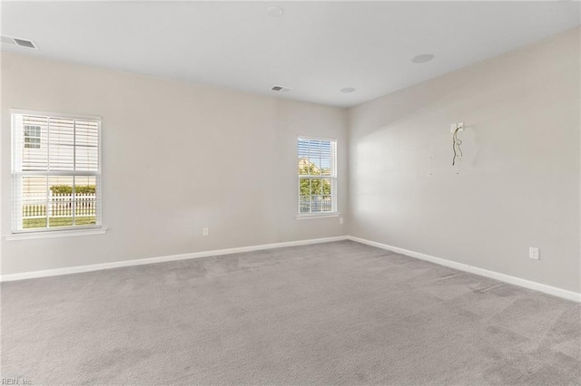 spare room with baseboards, carpet, and visible vents