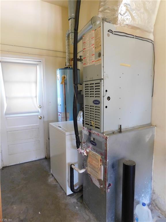 utility room with heating unit, washer / clothes dryer, and gas water heater