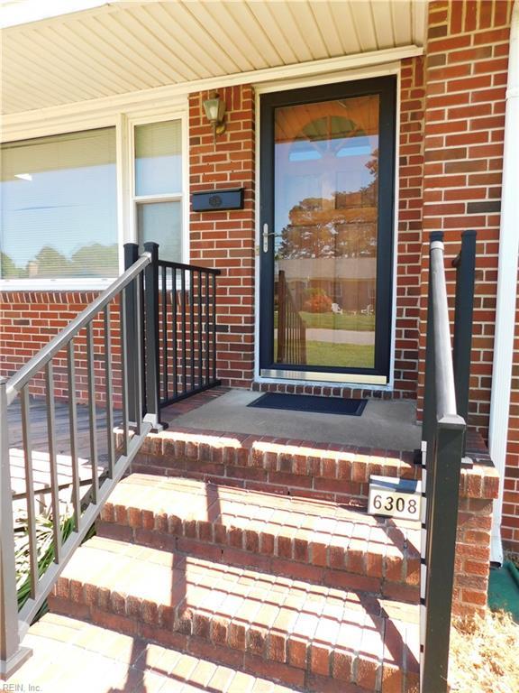 property entrance with brick siding and covered porch
