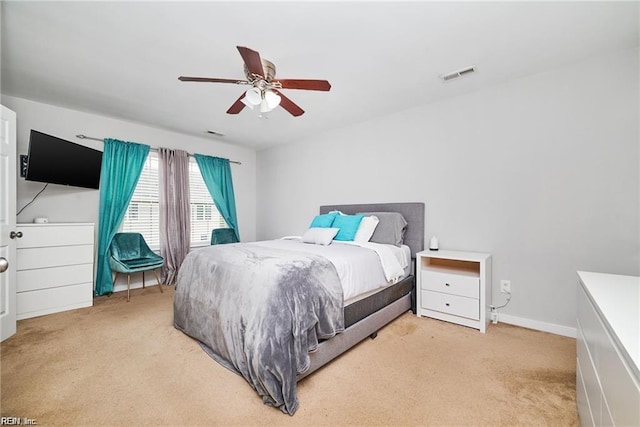 bedroom with visible vents, a ceiling fan, baseboards, and light carpet