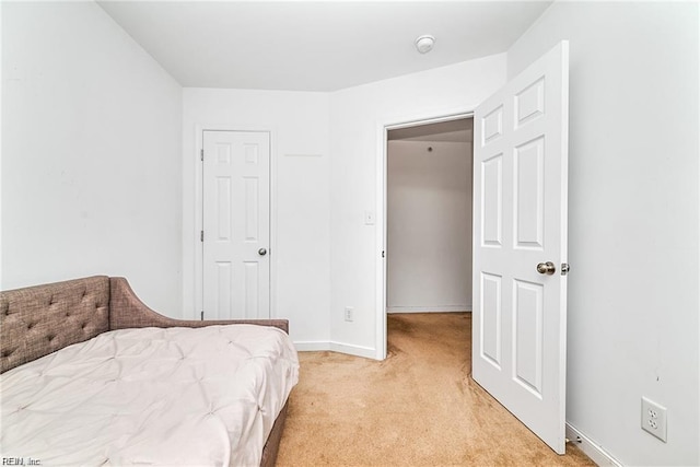 bedroom with light colored carpet and baseboards