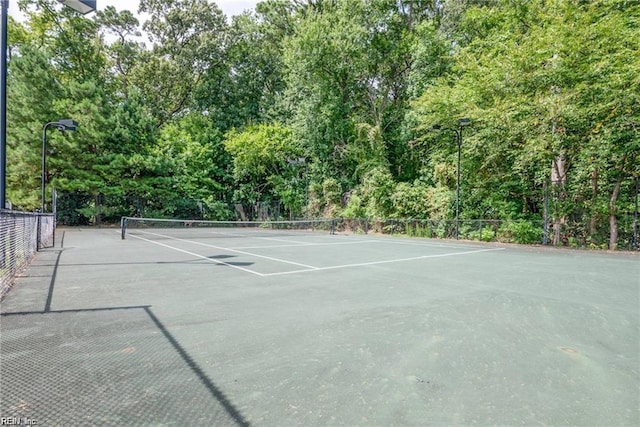 view of tennis court featuring fence