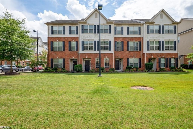 view of front of house featuring a front lawn and brick siding