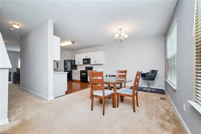 dining area featuring carpet floors, baseboards, and a chandelier