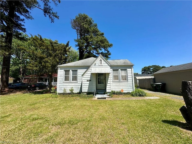bungalow-style home with a front yard and entry steps