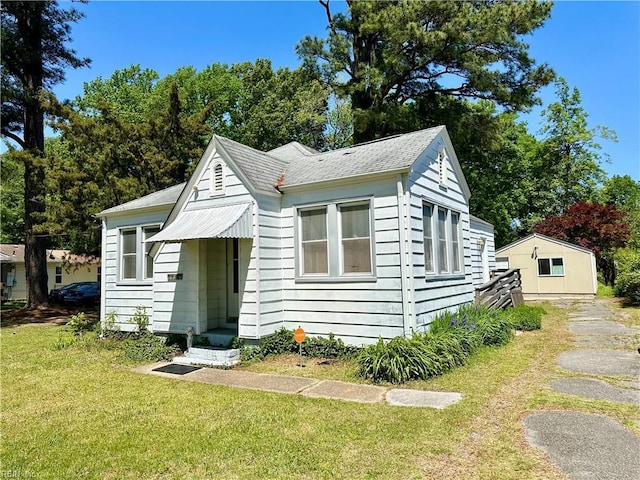bungalow-style house with a front lawn and roof with shingles