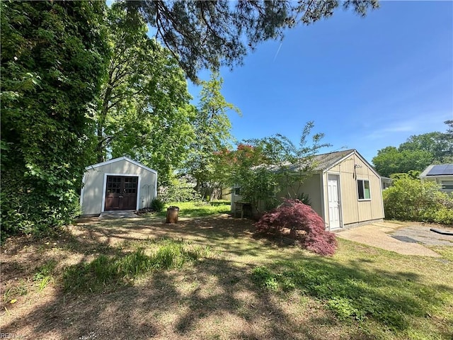 view of yard featuring a storage shed and an outbuilding