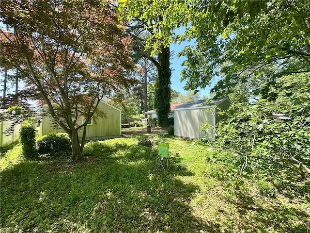 view of yard featuring a storage shed and an outbuilding