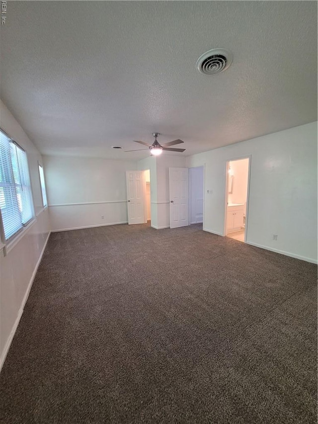empty room with a ceiling fan, carpet flooring, a textured ceiling, and visible vents