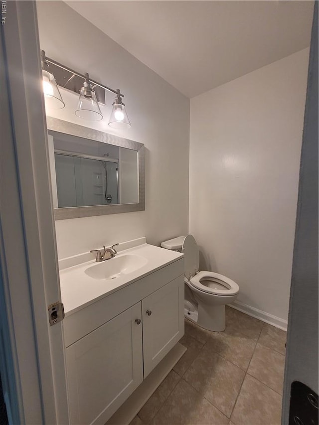 full bathroom featuring vanity, toilet, tile patterned floors, baseboards, and a shower stall