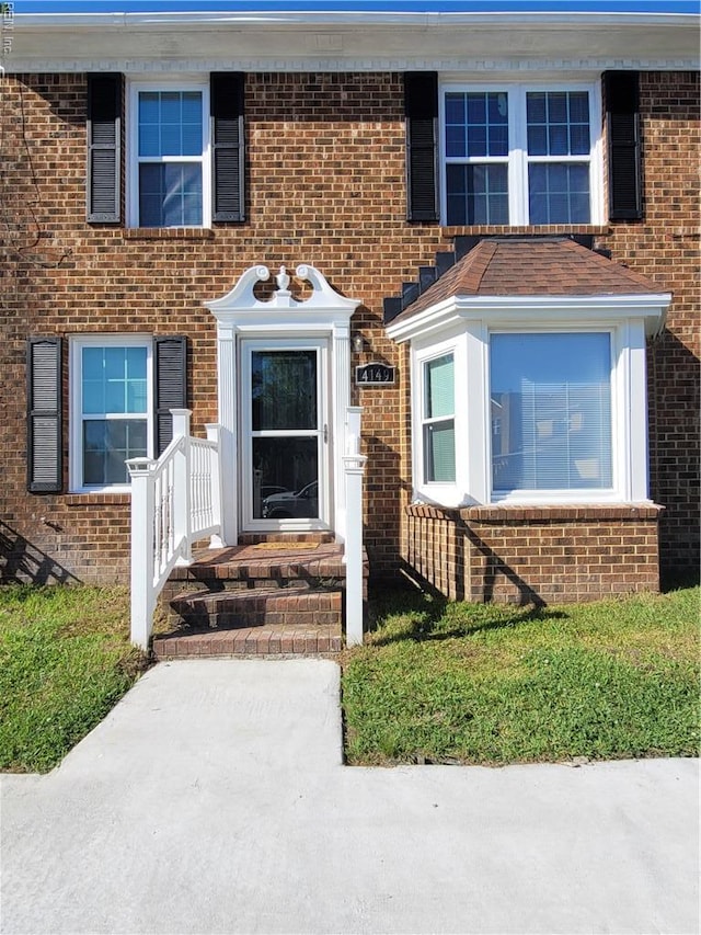 view of exterior entry with brick siding