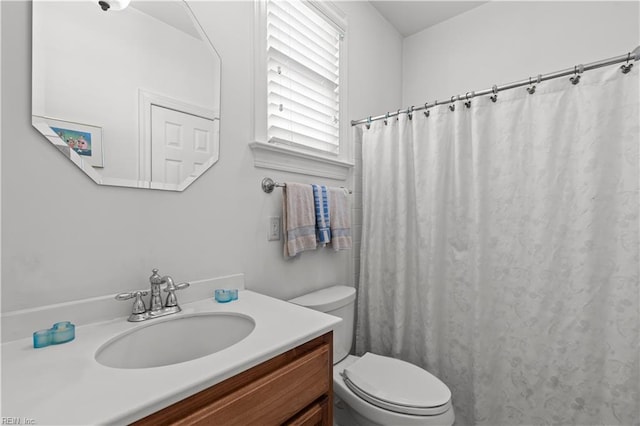 bathroom featuring toilet, a shower with shower curtain, and vanity