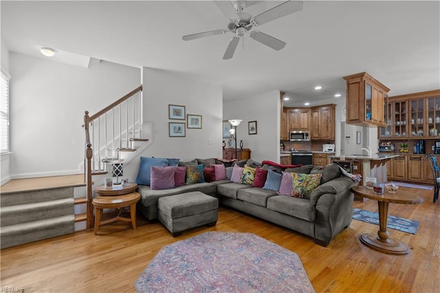 living area featuring light wood-type flooring, recessed lighting, a ceiling fan, and stairway