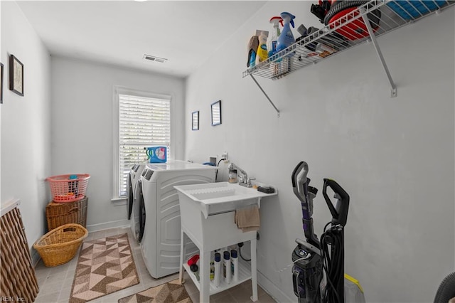 laundry room featuring laundry area, visible vents, baseboards, separate washer and dryer, and light tile patterned floors