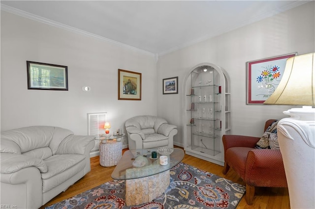 living area with ornamental molding and wood finished floors